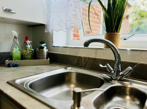 a stainless steel sink in a kitchen with a window at Bright & Sociable Home with Garden Retreat in Capel Saint Mary