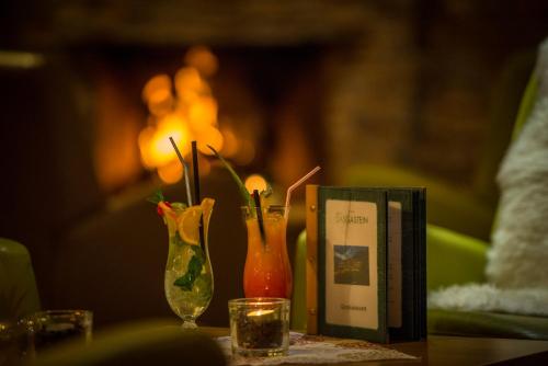 a table with two vases and a book on it at Hotel Das Gastein - ganzjährig inklusive Alpentherme Gastein & Sommersaison inklusive Gasteiner Bergbahnen in Bad Hofgastein