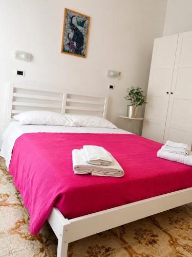 a white bed with a pink blanket on it at Azzurro Beach Hotel Igea Marina in Bellaria-Igea Marina