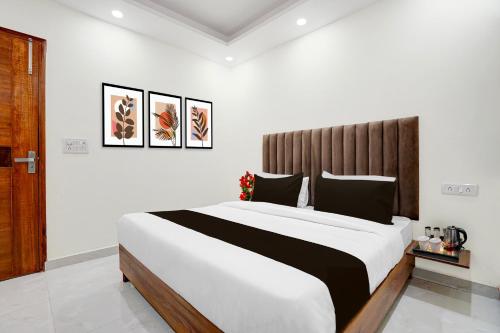 a bedroom with a large bed with a wooden headboard at Super Townhouse Krishna Nagar Metro Station in New Delhi