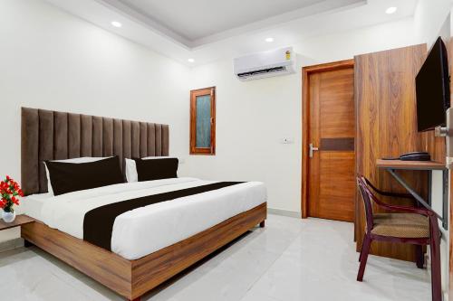 a bedroom with a large bed and a television at Super Townhouse Krishna Nagar Metro Station in New Delhi