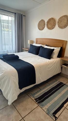 a bedroom with a large bed with blue pillows at 28 Kabeljauws in Jeffreys Bay