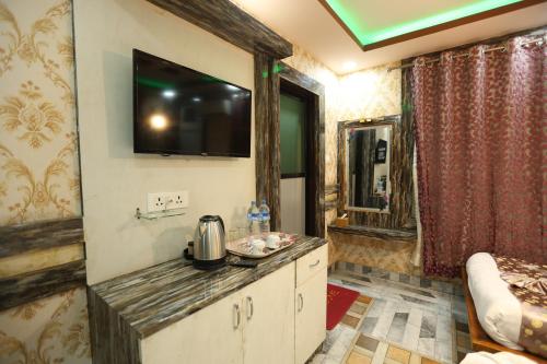 a room with a kitchen with a tv on the wall at Hotel Royal Sen in Lālbhitti