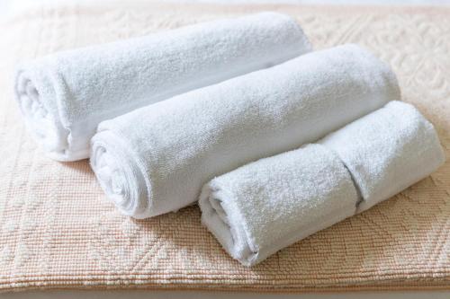 three rolls of white towels sitting on a table at Sa Murta Bianca Guesthouse Budoni in Budoni
