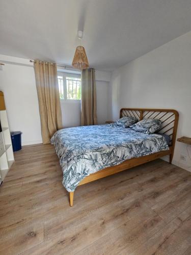 a bedroom with a bed with a blue comforter at Cottage Fonsorbes RDC Maison in Fonsorbes