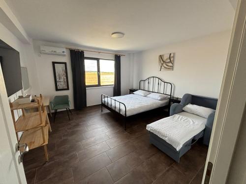 a bedroom with two beds and a couch and a window at SeaEsta Studio in Agigea
