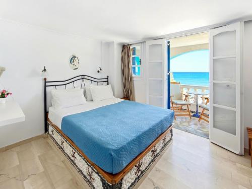 a bedroom with a bed and a view of the ocean at Stavros Beachfront Domes by Booking Kottas in Perivolos