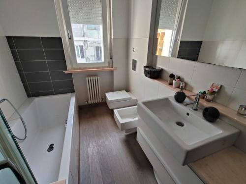 a bathroom with a sink and a toilet and a mirror at Il giardino di Ely in Senigallia