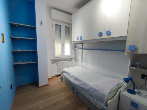a bedroom with a bed with blue walls and white cabinets at Il giardino di Ely in Senigallia