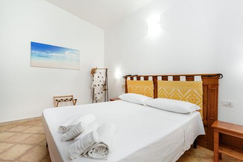 a bedroom with a white bed with towels on it at Sa Murta Bianca Guesthouse Budoni in Budoni