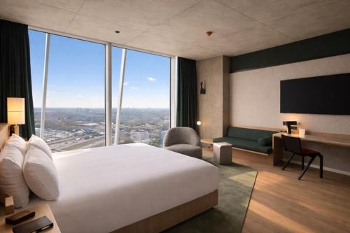 a hotel room with a large bed and large windows at Estrel Tower in Berlin