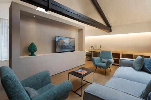 a living room with couches and chairs and a tv at Habitat Boutique Hotel in Catania
