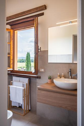 a bathroom with a sink and a mirror and a window at Tenuta dell'Oca Satolla in Pergine Valdarno