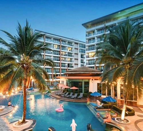a hotel pool with palm trees and a resort at Stay Kata in Kata Beach