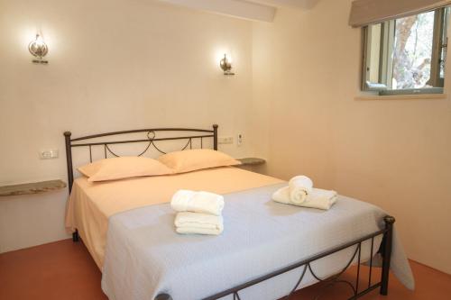 a bedroom with a bed with towels on it at Limni house in Kythira