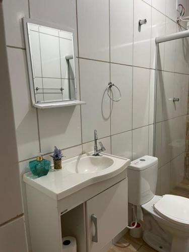 a white bathroom with a sink and a toilet at Hotel Real Ipiranga in Três Marias