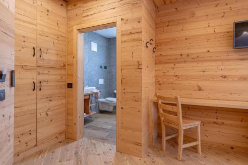 a wooden room with a wooden chair and a bathroom at Agritur Fiordaliso in Predaia