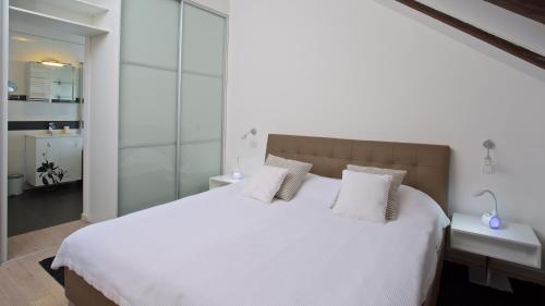 sypialnia z dużym białym łóżkiem z 2 poduszkami w obiekcie Xaver Luxury Apartments w Zagrzebiu