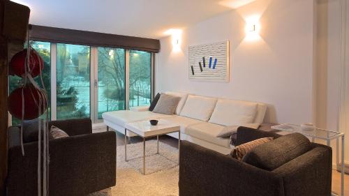 salon z białą kanapą i 2 krzesłami w obiekcie Xaver Luxury Apartments w Zagrzebiu
