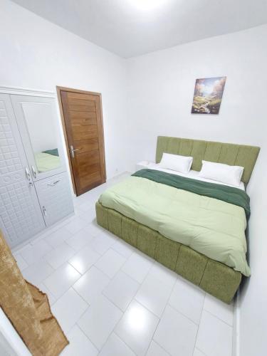 a bedroom with a bed in a white room at Horizon Bleu Cozy prés de la Plage avec Balecon in Dakar