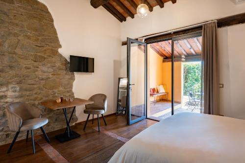 a bedroom with a stone wall and a table and chairs at Tenuta dell'Oca Satolla in Pergine Valdarno