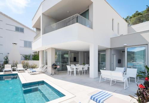a villa with a swimming pool and a patio at Villa Maslina in Vela Luka