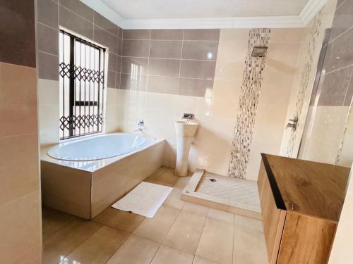 a bathroom with a bath tub and a shower at The Social in Burgersfort