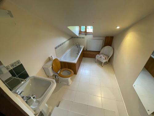 a bathroom with a tub and a toilet and a sink at 16th Century Devon Farmhouse Stunning Views in Winkleigh