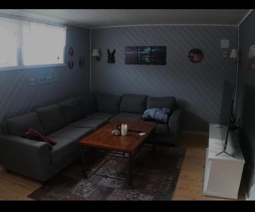 a living room with a couch and a coffee table at Komfortabel overnatting på veien mot Nordkapp in Kolvik