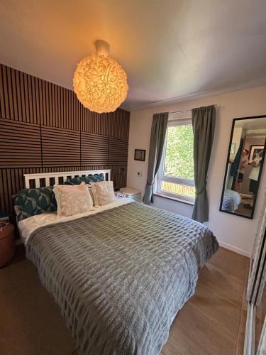 a bedroom with a large bed and a chandelier at Cosy home in Edinburgh in Edinburgh