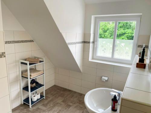 a white bathroom with a sink and a window at Alpenstube Ockholm in Ockholm