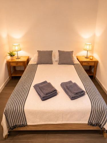 a bedroom with a large bed with two towels on it at Jack&Lily's in Évora