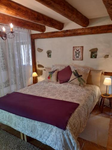 a bedroom with a large bed in a room with wooden ceilings at Le Pre Vert - Garden Suite in Marat