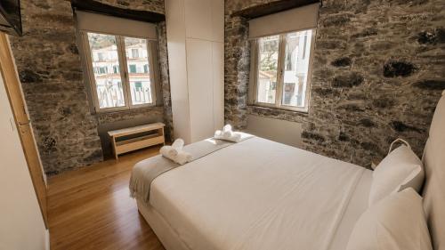 a bedroom with a bed with two stuffed animals on it at Heritage Apartments in Câmara de Lobos