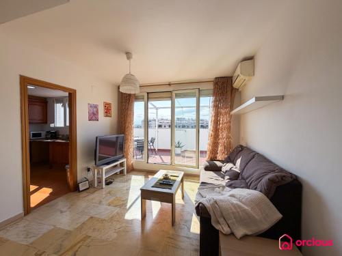a living room with a couch and a tv at The Skyline in Grao de Castellón