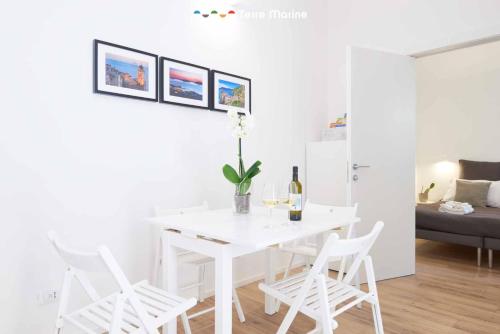 a white dining room with a white table and chairs at Urban Chic, Terre Marine in La Spezia