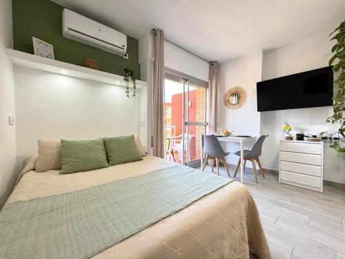 a bedroom with a bed and a kitchen and a table at Hercules Cozy Studio - City Center and Near Beach in Benalmádena