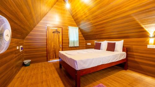 a bedroom with a bed in a wooden cabin at lake Edge Dambulla in Dambulla