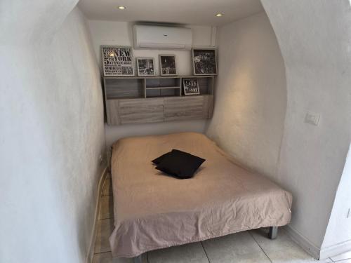 a small bedroom with a bed in a corner at Studio Danna in Menton