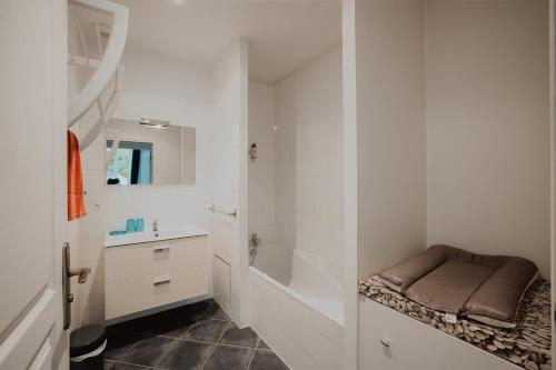 a bathroom with a sink and a tub and a toilet at Le gîte de Bresteau in Beillé