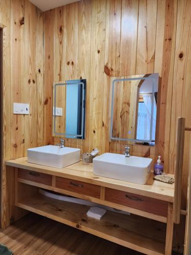 a bathroom with two sinks and two mirrors at Coffee Myhome in Kon Rung (1)