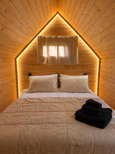a bedroom with a bed in a wooden room at Bela Resort - Glamping in Motnik