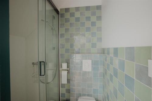 a bathroom with a glass shower and a toilet at L'annexe de Bresteau in Beillé