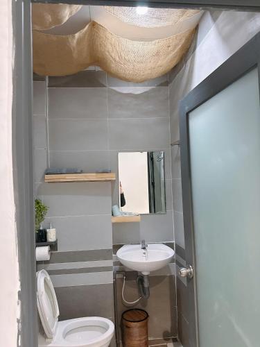 a bathroom with a white toilet and a sink at T - Bona Homestay in Xã Thang Tam