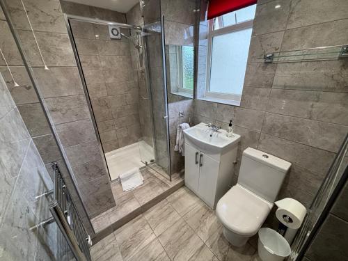 a bathroom with a shower and a toilet and a sink at 1 Bedroom Chalet in West Runton