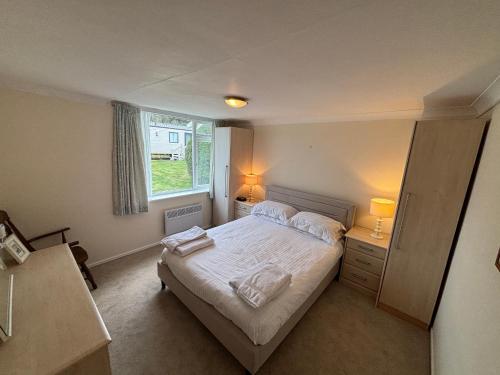 a bedroom with a bed with two towels on it at 1 Bedroom Chalet in West Runton