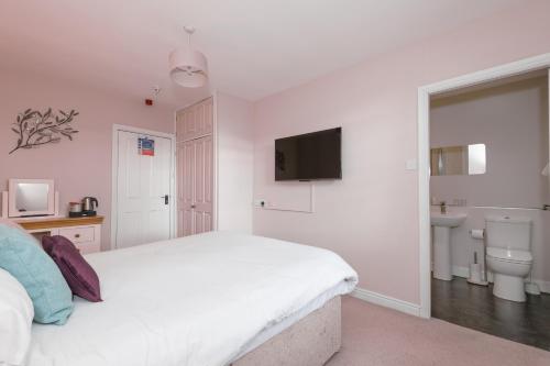 a white bedroom with a bed and a sink at Sandfordarms in Appleby