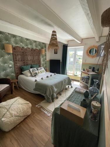a bedroom with a large bed and a couch at Chez TROTRO in Saint-Pierre-de-Plesguen