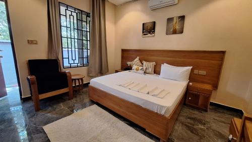 a bedroom with a large bed and a chair at Escape Villa - Kilimanjaro in Moshi
