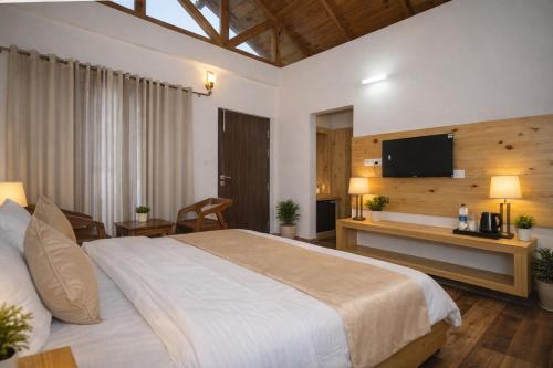 a bedroom with a large bed and a television at Aesquire Hotel in Bhīm Tāl